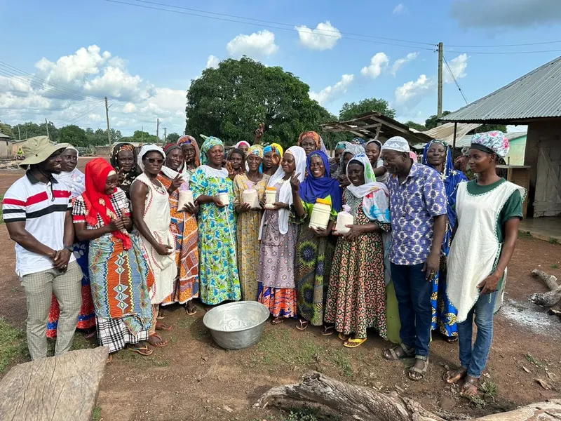 Cooperative members holding bowls of shea butter they processed